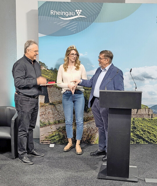 Bei der bergabe der Ehrennadel (v. l.): Gerhard Bollig (Trger der Ehrennadel), Lena Orth (Rheingauer Weinknigin) und Peter Seyffardt (Rheingauer Weinbauprsident).