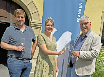 Der Vorsitzende des VDP Franken Robert Haller (rechts) und sein Stellvertreter Paul Weltner freuen sich ber den Besuch von Weinknigin Antonia Krai bei der Weinprsentation in Wrzburg. 