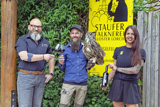 In der Falknerei (v. l.): Albrecht Schurr (Geschäftsführer Fellbacher Weingärtner), Erik Pelz (Falkner Stauferfalknerei) mit Quentin (Europäischer Uhu) und Nadine Maier (Mitarbeiterin Stauferfalknerei).