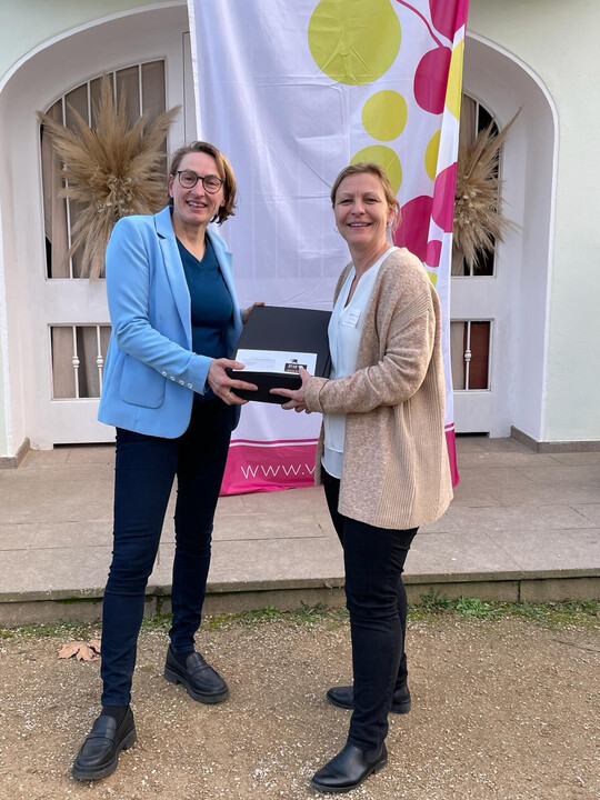 Übergabe bei der Winzergenossenschaft Mayschoss-Altenahr (v. l.): Astrid Ricker (Kellermeisterin Winzergenossenschaft Mayschoss-Altenahr) übernimmt die Spende von Ramona Fischer (Geschäftsführerin Teamwerk Esslingen).