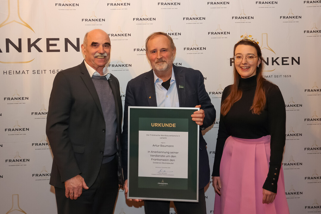 Der Prsident des Frnkischen Weinbauverbands Artur Steinmann (links) bergibt zusammen mit der 66. Frnkischen Weinknigin Lisa Lehritter an Artur Baumann den Goldenen Bocksbeutel, die hchste Auszeichnung der frnkischen Weinwirtschaft.