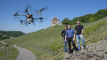 Sprhdrohne DJI Agras T16 auf einer Versuchsflche der LVWO Weinsberg. Personen auf dem Bild (von links nach rechts): Johannes Bertsch (Dronexperts), Dr. Manuel Becker (LVWO Weinsberg), Mischa Kohnen (Droneparts).
