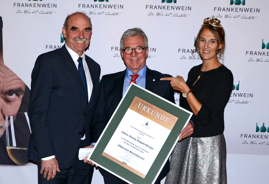 : Weinbauprsident Artur Steinmann und Weinknigin Silena Werner zeichneten Oskar G. Noppenberger mit dem Silbernen Bocksbeutel aus.      