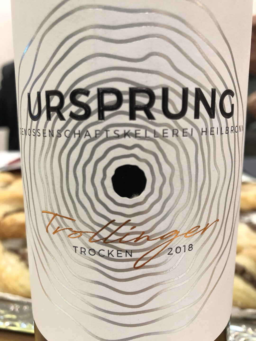 Die Ringe symbolisieren die Jahresringe der alten Reben, an denen die Trauben wachsen. Das Wrtchen "Ursprung" ist durch eine besondere Drucktechnik hervorgehoben und verleiht dem Etikett Haptik.