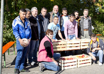 LWG-Mitarbeiter Andreas Lsch und Brigitte Engelhardt bergeben einen Teil der Apfel-Spende an Waldemar Brohm, Peter Etthfer (erster und zweiter Brgermeister) und die Bewohner der Notunterkunft in Margetshchheim.