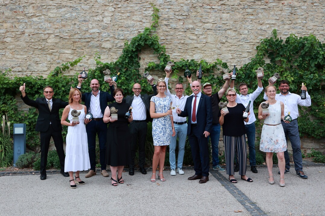 Die zehn strahlenden Sieger von Best of Gold 2022 mit der 65. Fränkischen Weinkönigin Eva Brockmann, Weinbaupräsidenten Artur Steinmann und Hermann Mengler im Tagungszentrum Himmelspforten.