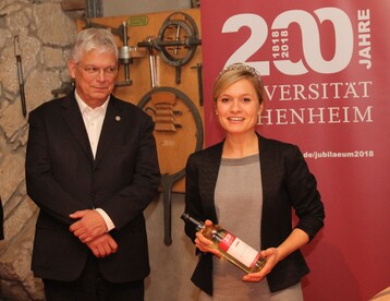Universittsrektor Prof. Dr. Stephan Dabbert lauscht Wrttembergs Weinknigin, die einen der Jubilumsweine des Hauses vorstellt. 