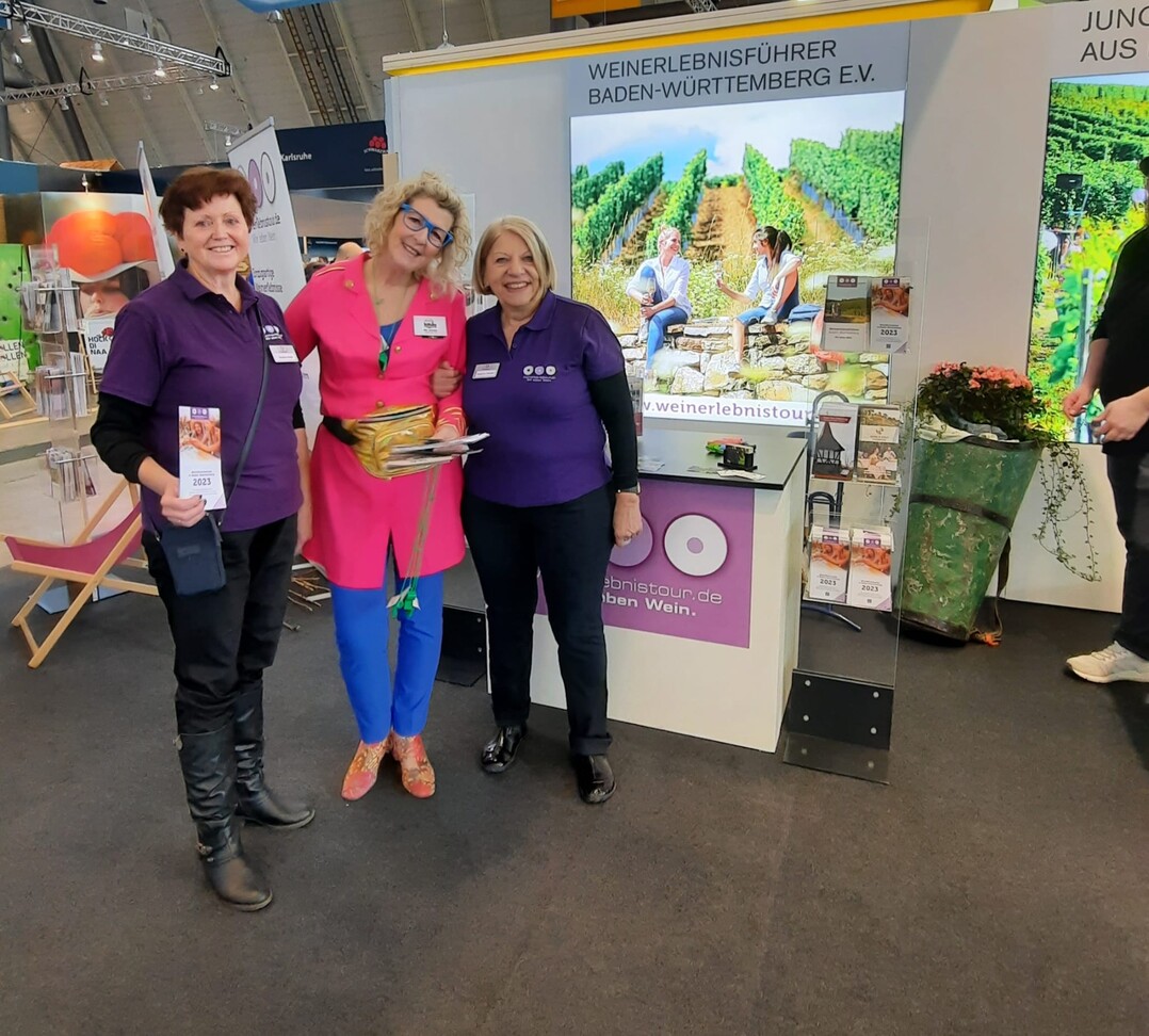 Drei Weinerlebnisführerinnen informieren die Besucher am Messe-Stand.